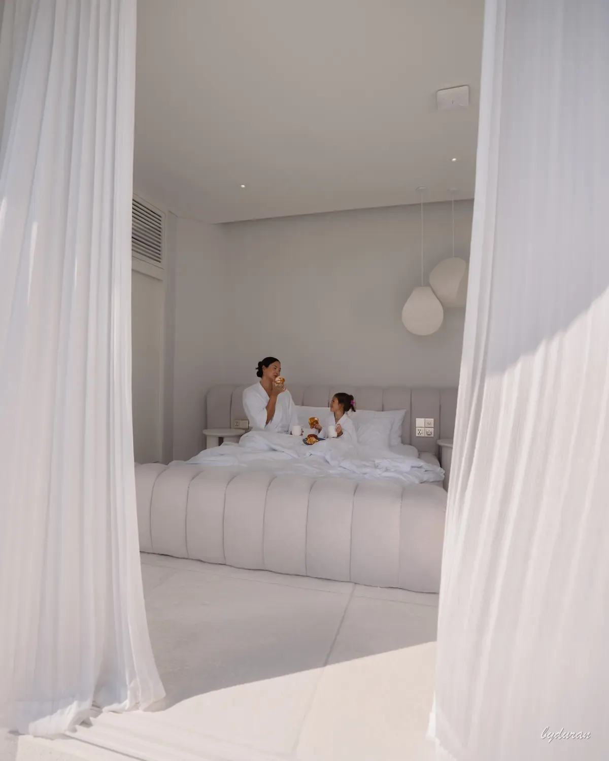 Villa interior — mom and daughter morning breakfast in bed