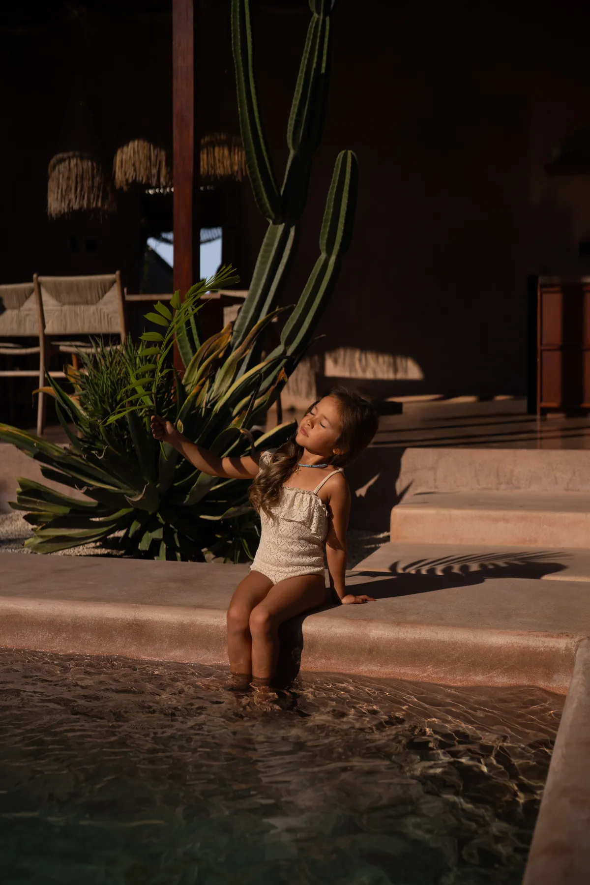 Editorial lifestyle: girl at pool steps, golden hour